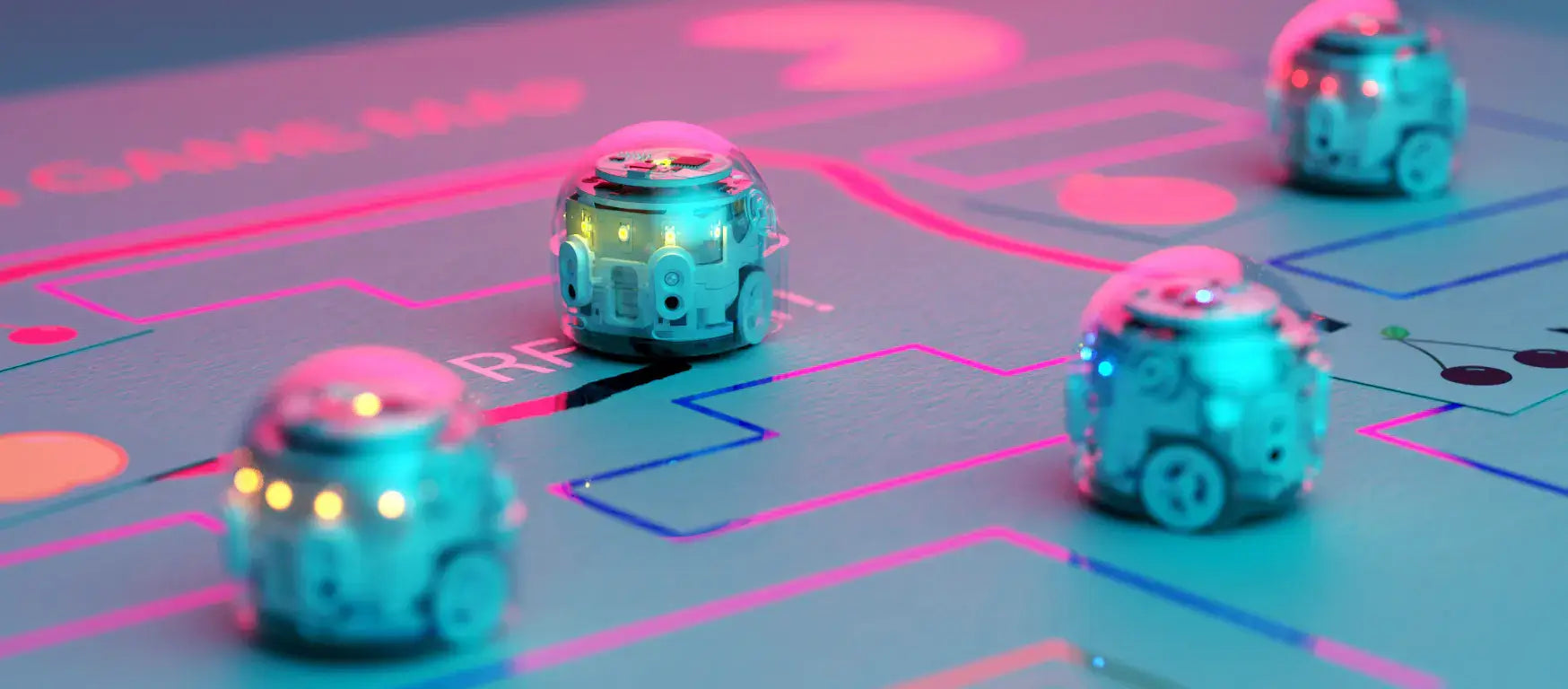 Colorful Ozobot robots navigating a bright game map, illustrating coding in the classroom.