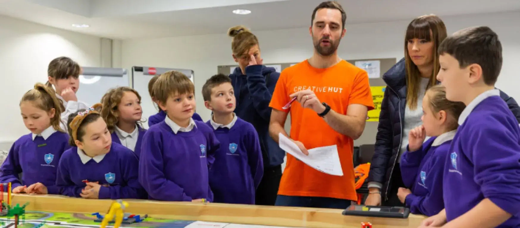 A CreativeHUT instructor engages with schoolchildren during a FIRST® LEGO® League workshop.