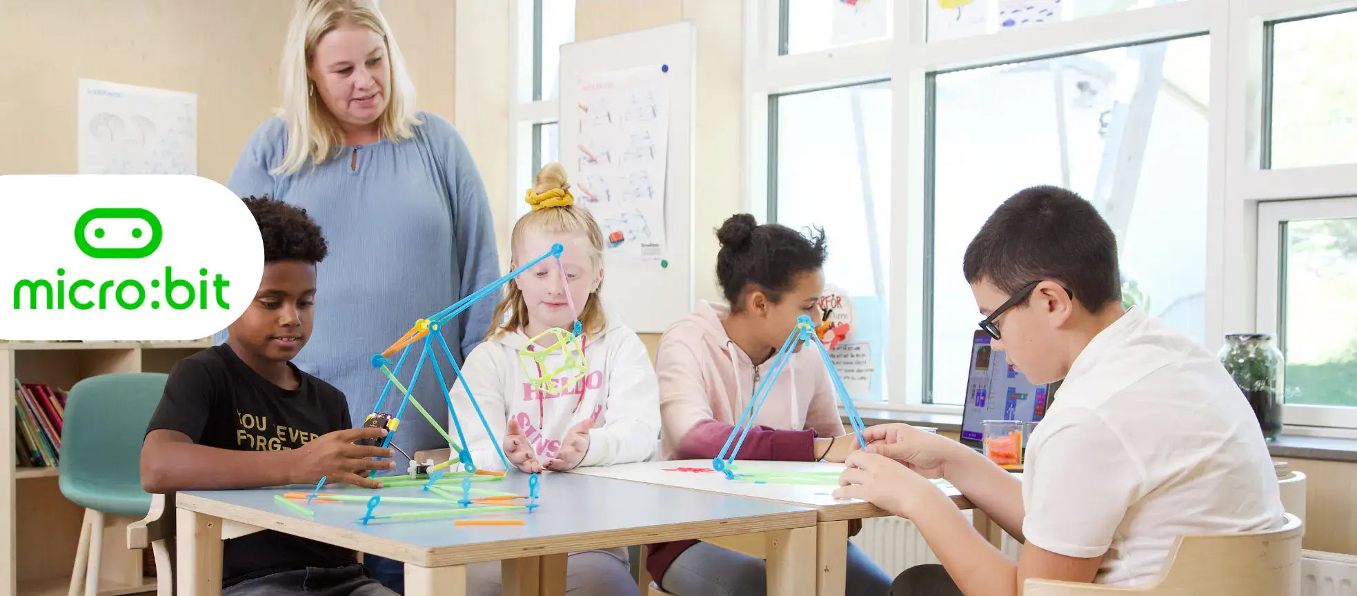 Students learning with Micro:bit and Strawbees in a classroom, promoting coding and creativity.