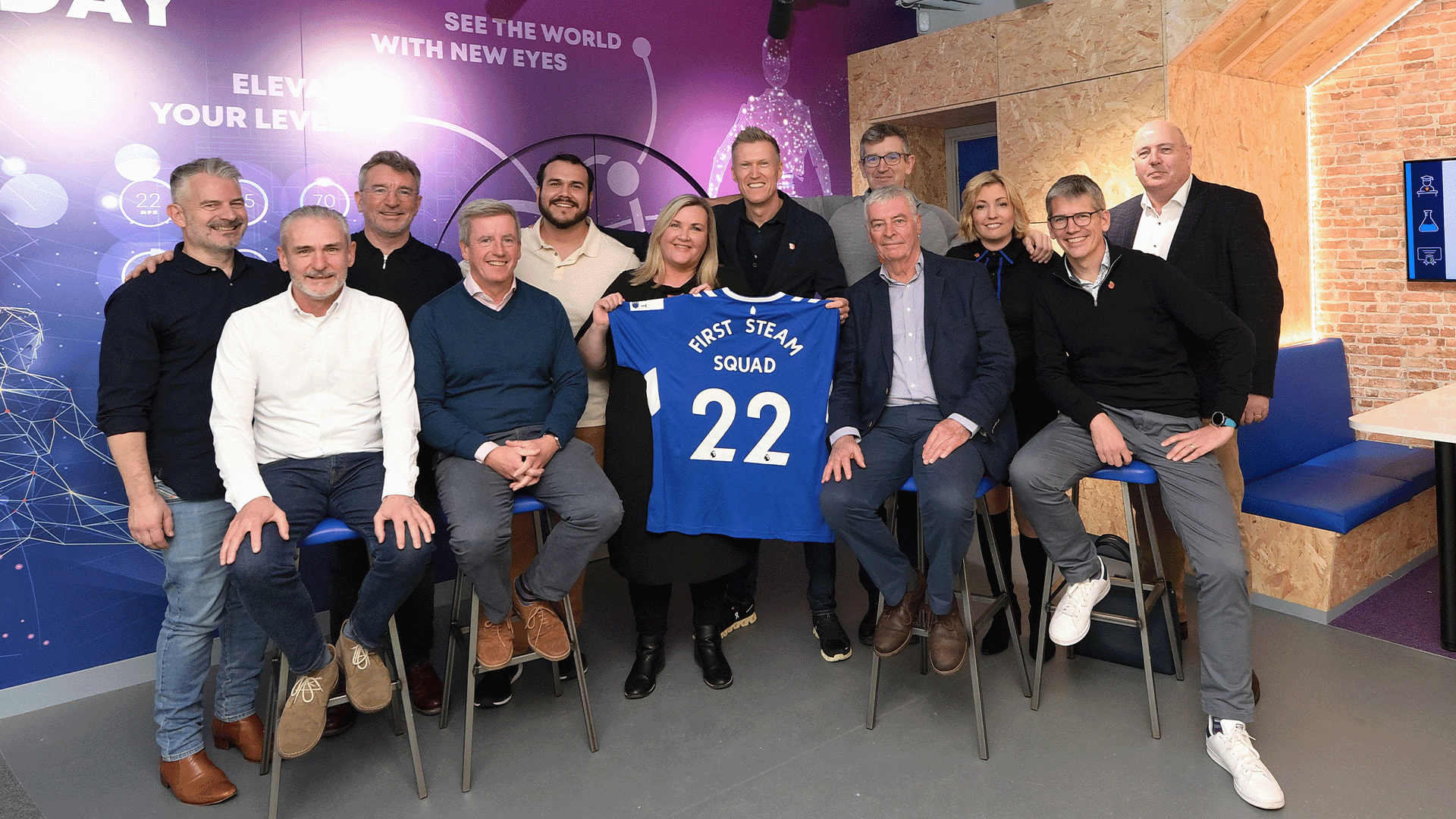 Group photo at Everton's Digital Skills Lab in Merseyside, featuring team members holding a blue jersey with '22'.