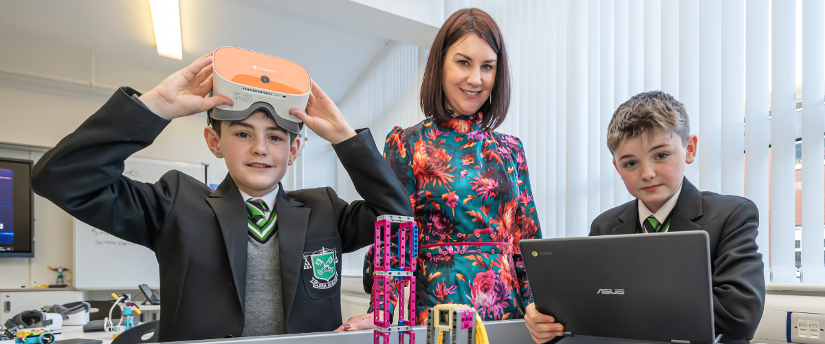 TechnoTeachers supporting students with technology education, featuring VR headset and laptop in a classroom setting.