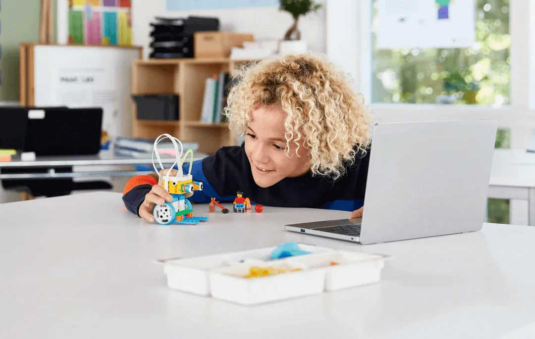 Child excitedly playing with a LEGO Education Primary set in a classroom, enhancing learning through creativity.