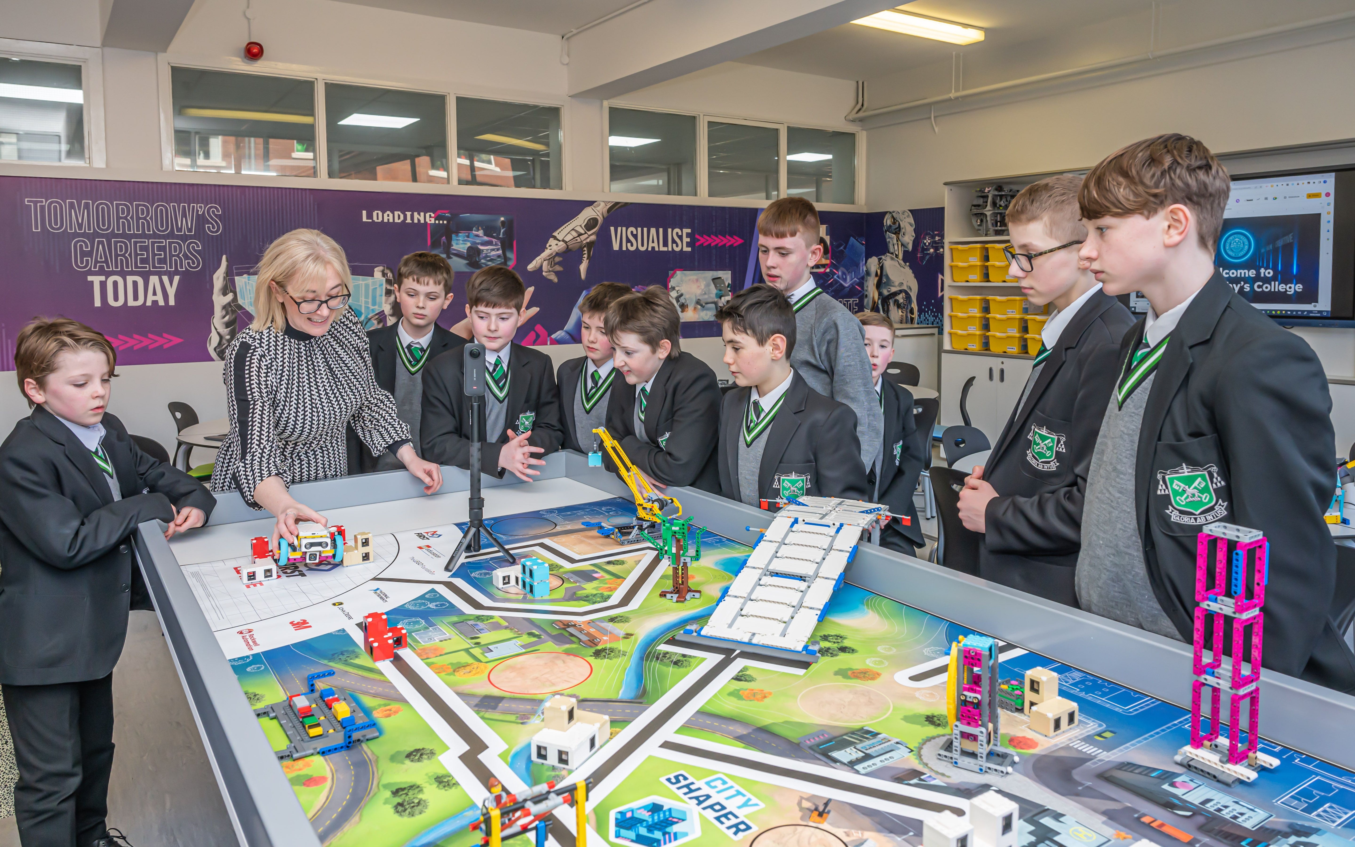 Students engaging with a hands-on learning activity at a technology workshop, guided by an instructor.