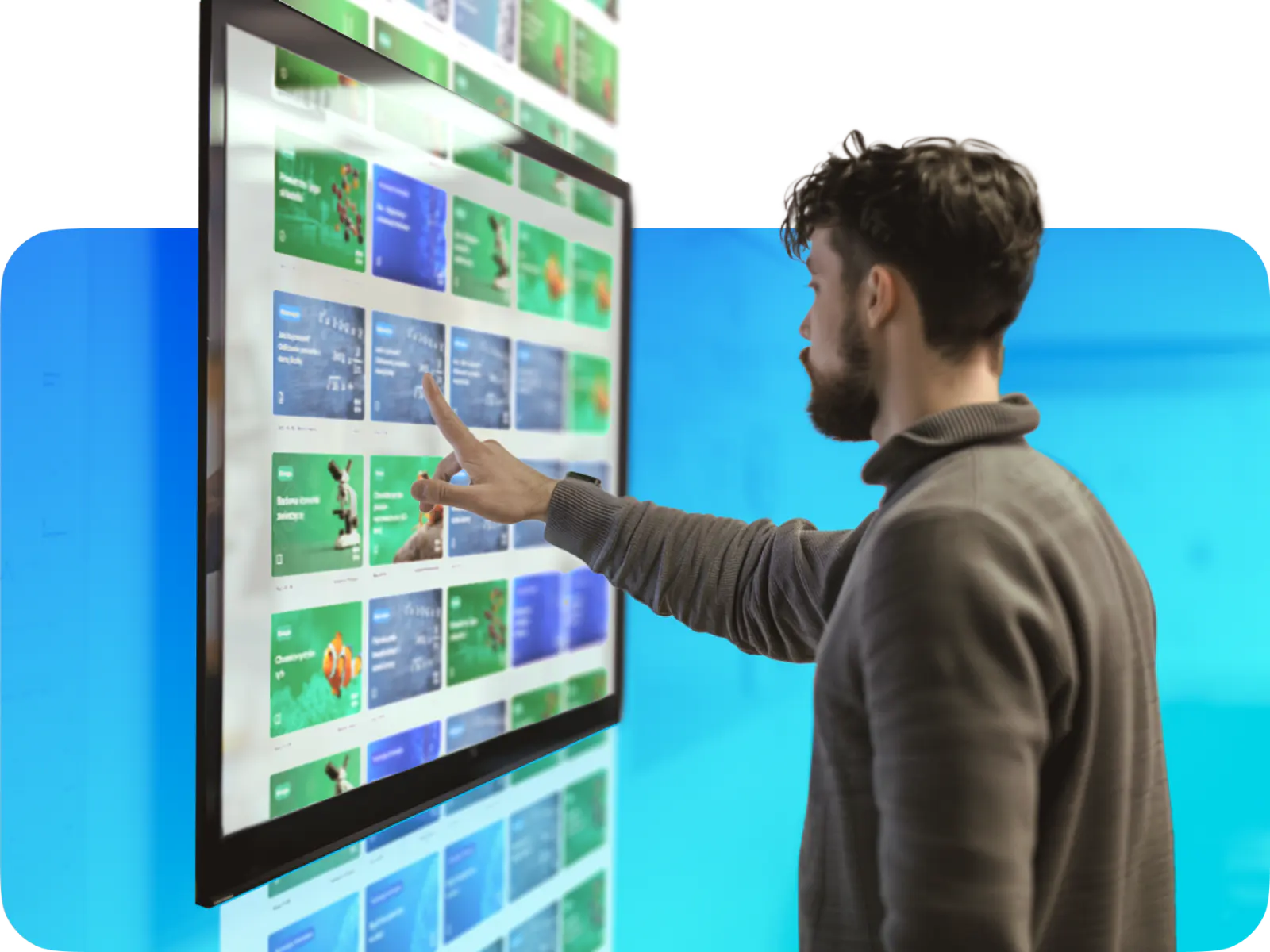 Person interacting with a digital touchscreen display showcasing a grid of applications or content.