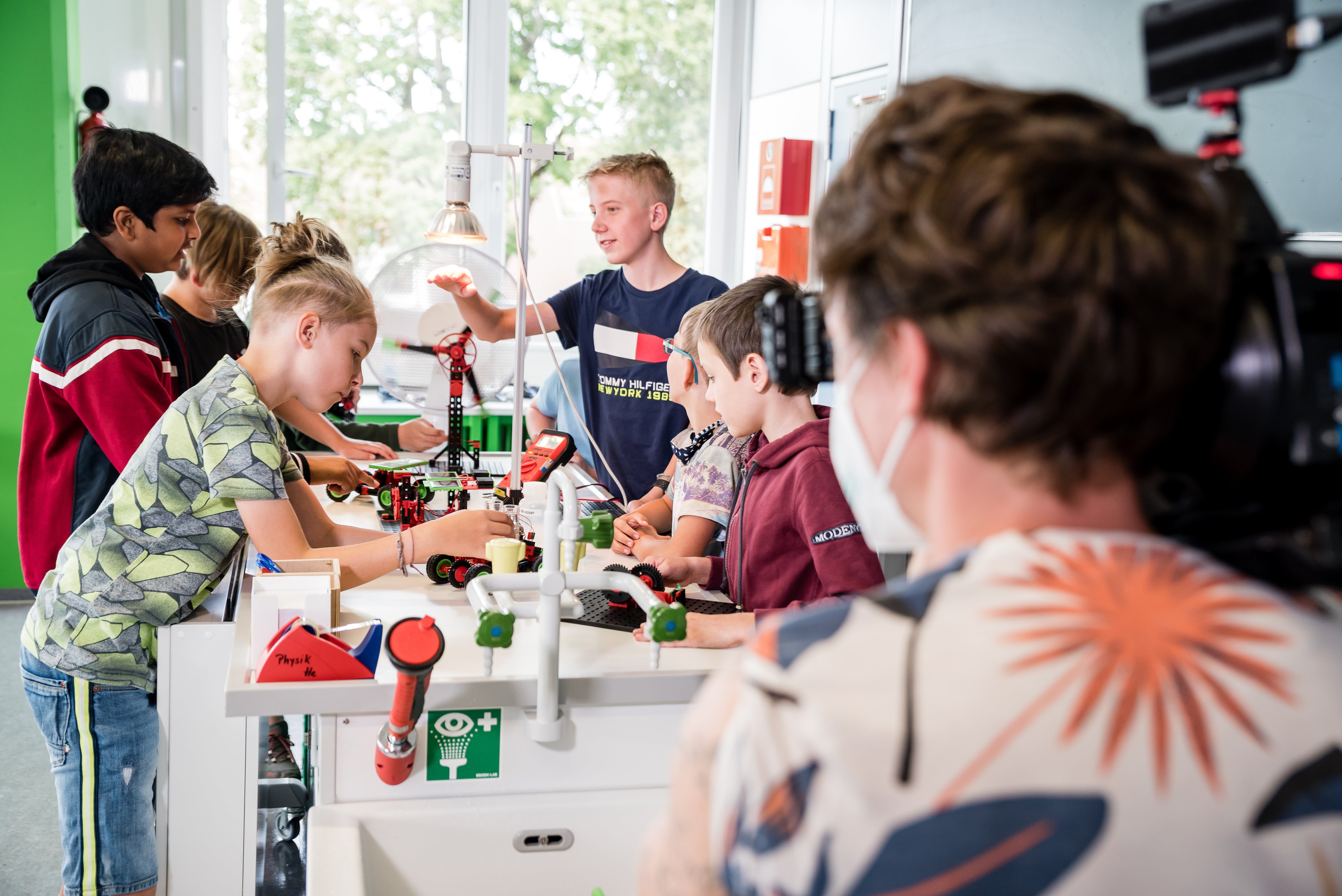 Children engaged in hands-on STEM learning, collaborating on projects at a modern educational workspace.