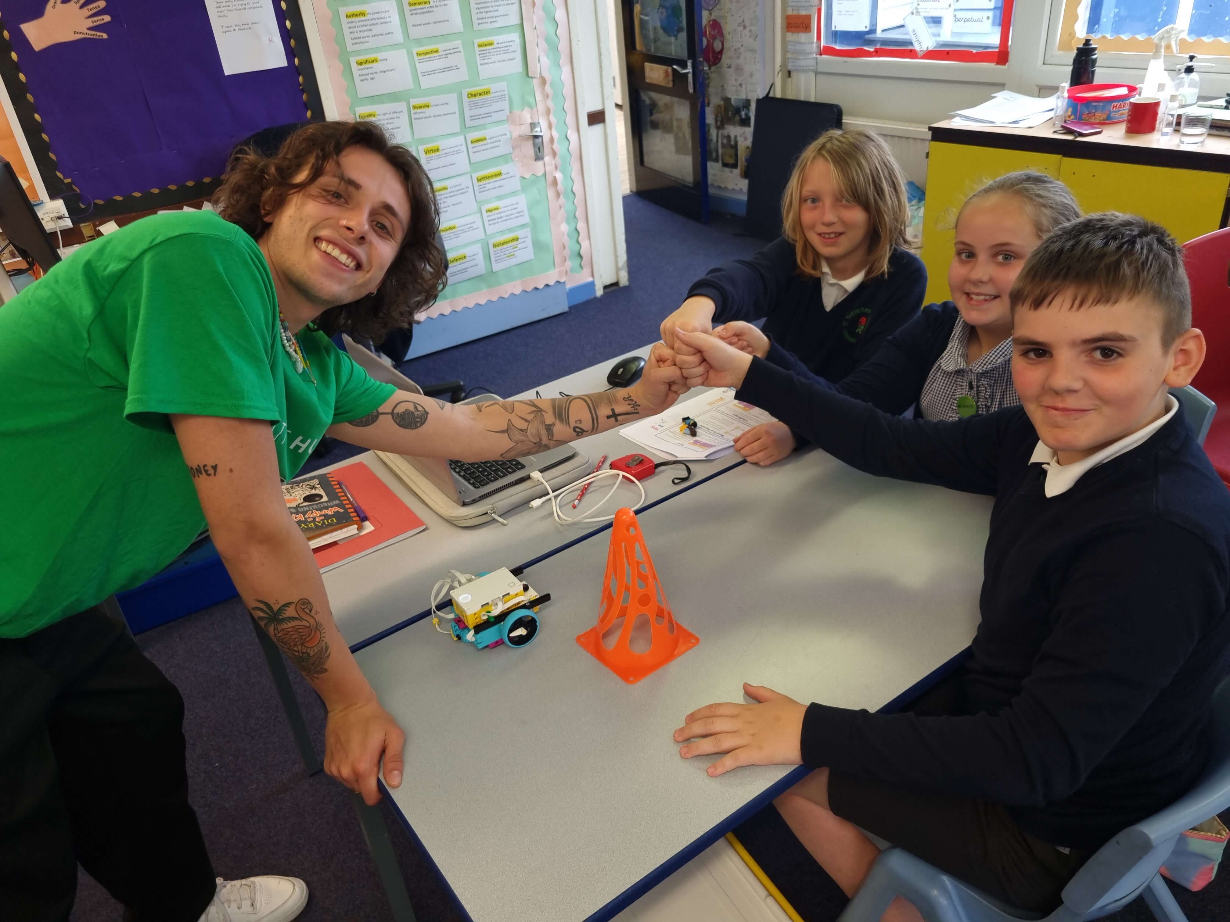 Teacher and students engaging in hands-on robotics project in a classroom setting.