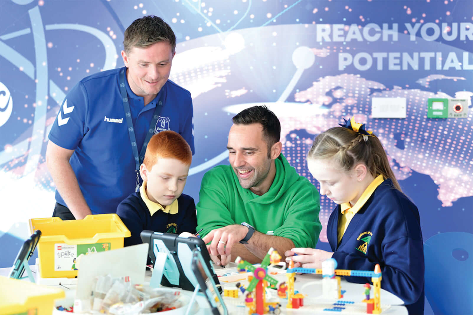 Two adults and two children engage in a fun educational activity with colorful building blocks.