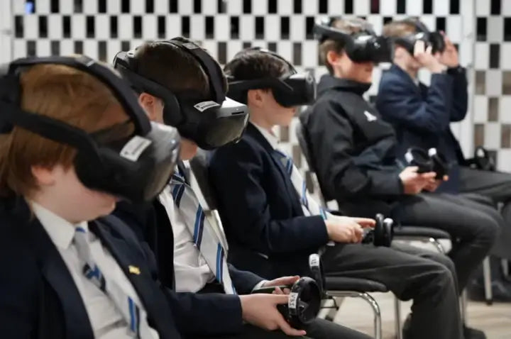 Students engaging in virtual reality gaming while wearing VR headsets in a classroom setting.
