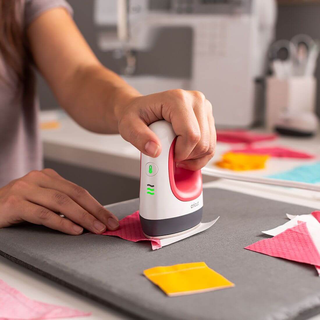 User demonstrating Cricut EasyPress Mini™ on fabric, showcasing its compact design for heat transfer projects.
