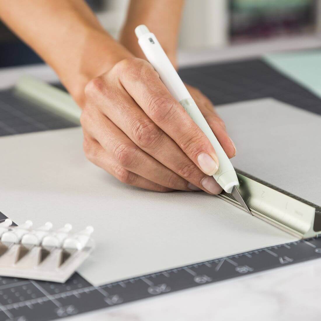 Person using Cricut TrueControl Knife on cardstock, demonstrating precision and control in crafting projects.