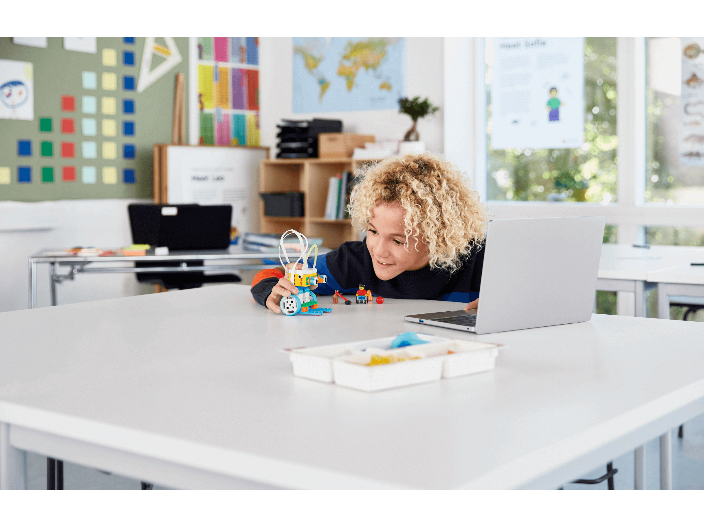 Student engaging with LEGO Education SPIKE Essential Set in a classroom, promoting hands-on STEAM learning.