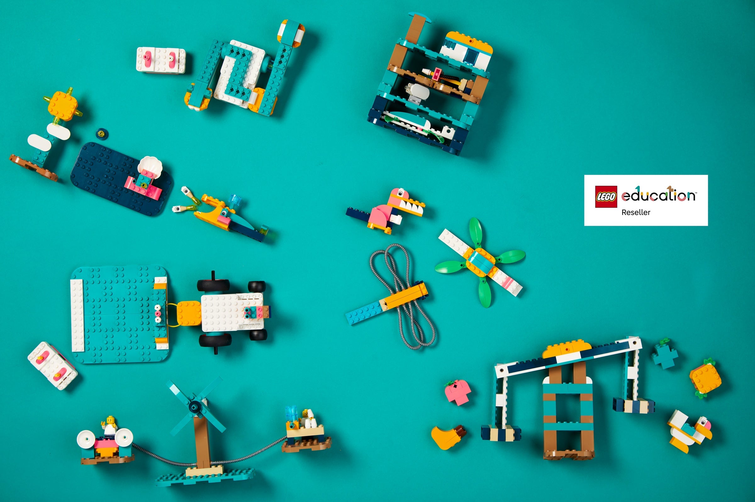 Flat lay of colorful LEGO Education sets on a turquoise background, showcasing creative building possibilities.