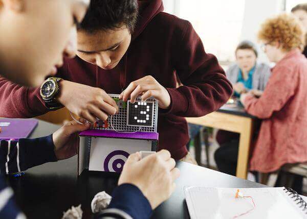 Students using littleBits Code Kit to create inventions and games in a classroom setting.