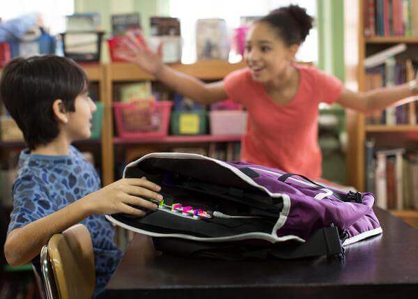 Two kids in a classroom excitedly engage with a backpack, showcasing creativity and exploration with littleBits STEAM kit.