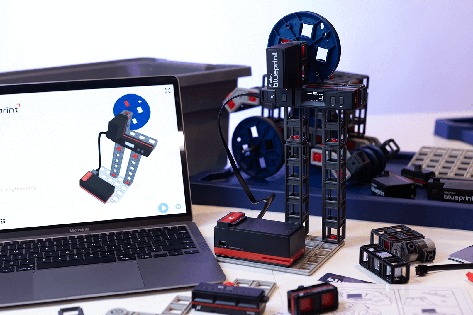 Sphero Blueprint Engineering Kit on a table with a laptop displaying design interface and various building components nearby.