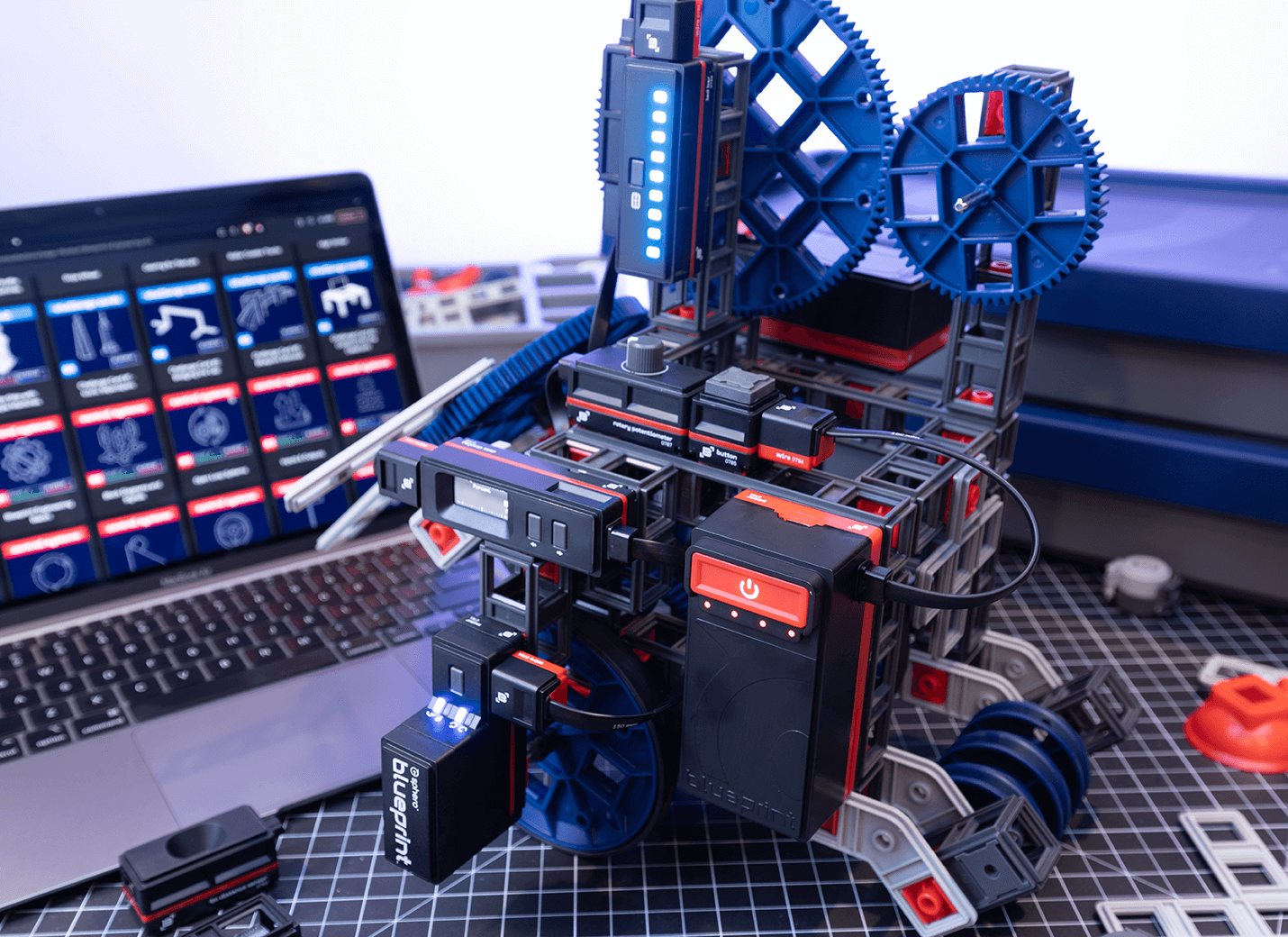 Sphero Blueprint Engineering Kit with sensors and motors on workspace, laptop displaying design instructions.