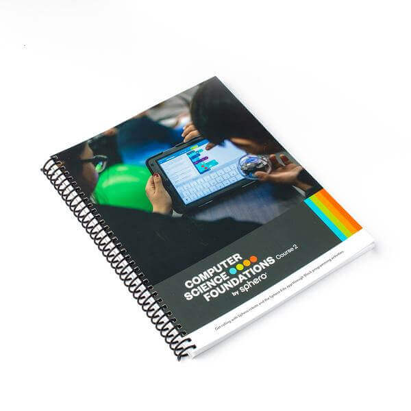 Spiral-bound Computer Science Foundations Course 2 textbook by Sphero with students learning programming.