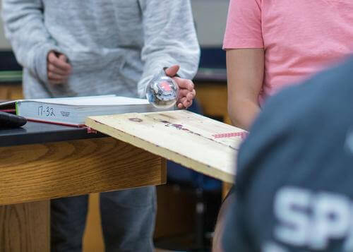 Students using Sphero robot on a ramp in a classroom setting for hands-on computer science activities.