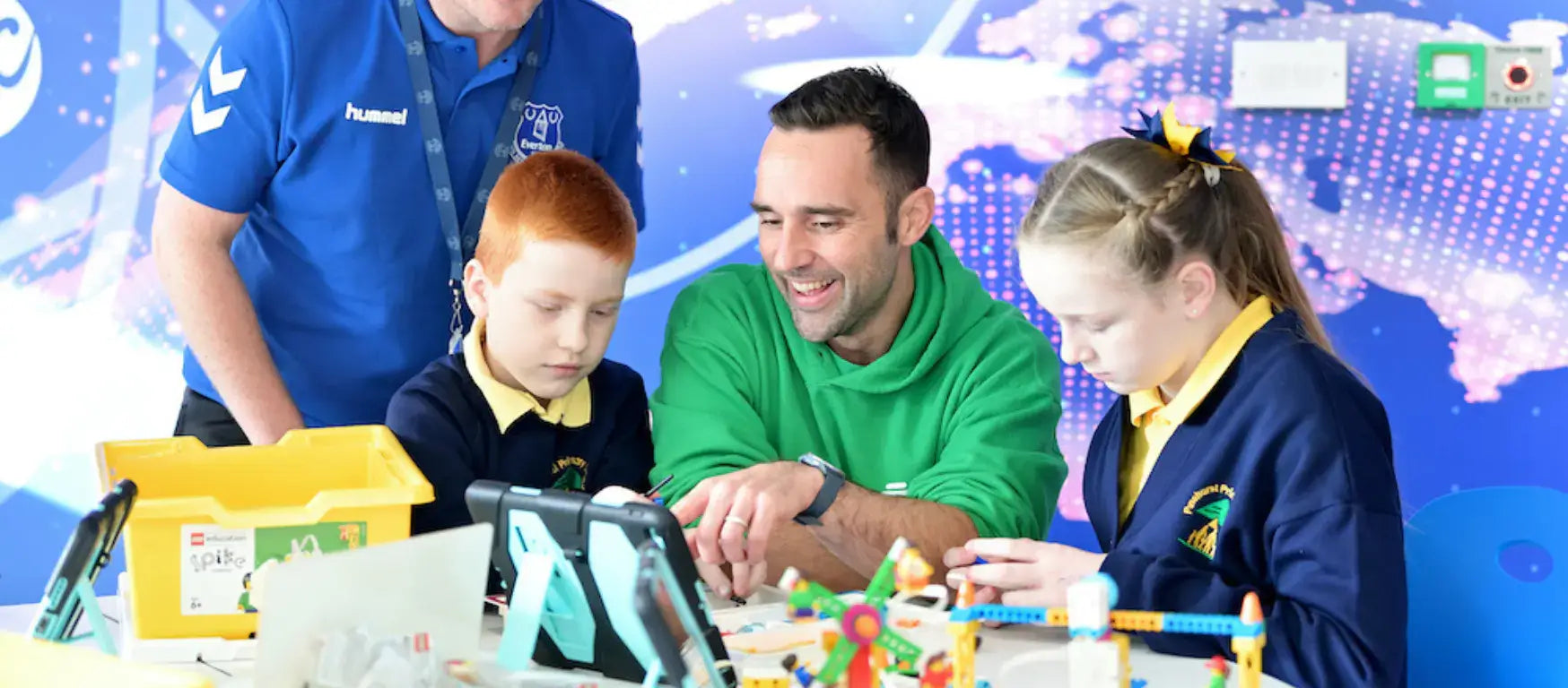 Participants engaging in digital skills activities at Everton In The Community lab, promoting learning and collaboration.