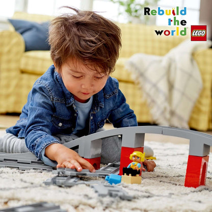 Child playing with LEGO® DUPLO Train Bridge and Tracks Set 10872, promoting creativity and fun in building.