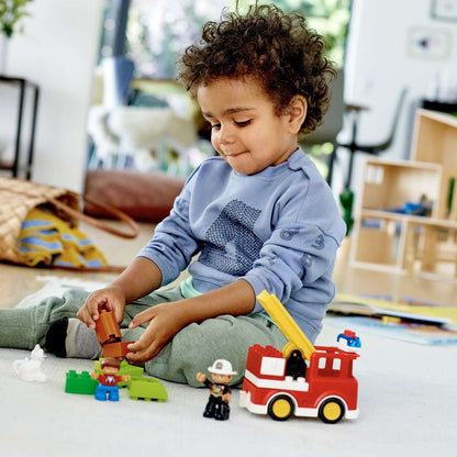 Child playing with LEGO® DUPLO Town Fire Truck set, engaging in imaginative play with firefighter and rescue theme.