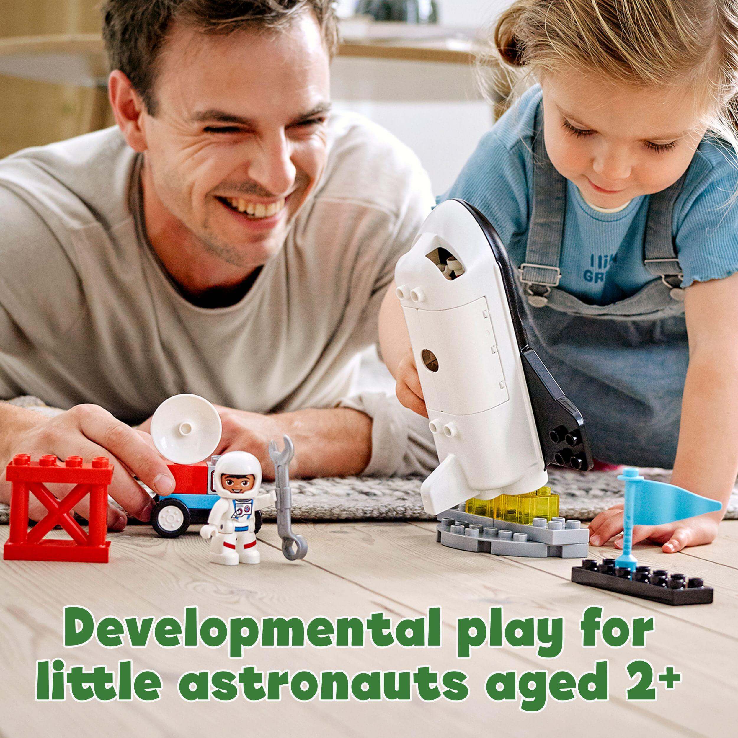 A father and daughter engaged in developmental play with LEGO® DUPLO Space Shuttle set for toddlers aged 2 and up.