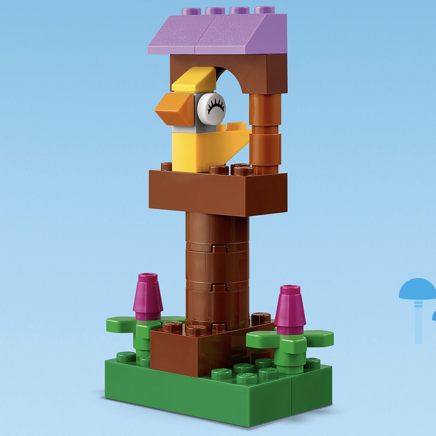 LEGO Classic Basic Brick Set 11002 birdhouse model with a yellow bird and flower accents.