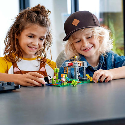 Kids playing with LEGO® Minecraft The Panda Nursery set, featuring cute pandas and a colorful building design.