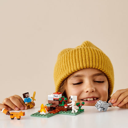 Child smiling with LEGO® Minecraft The Taiga Adventure Set 21162 featuring characters and a fox.