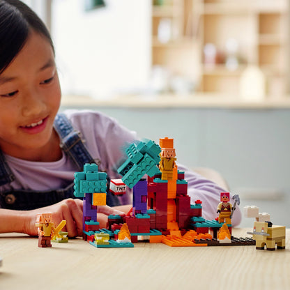 Child playing with LEGO® Minecraft The Warped Forest set, featuring characters, lava flows, and vibrant trees.