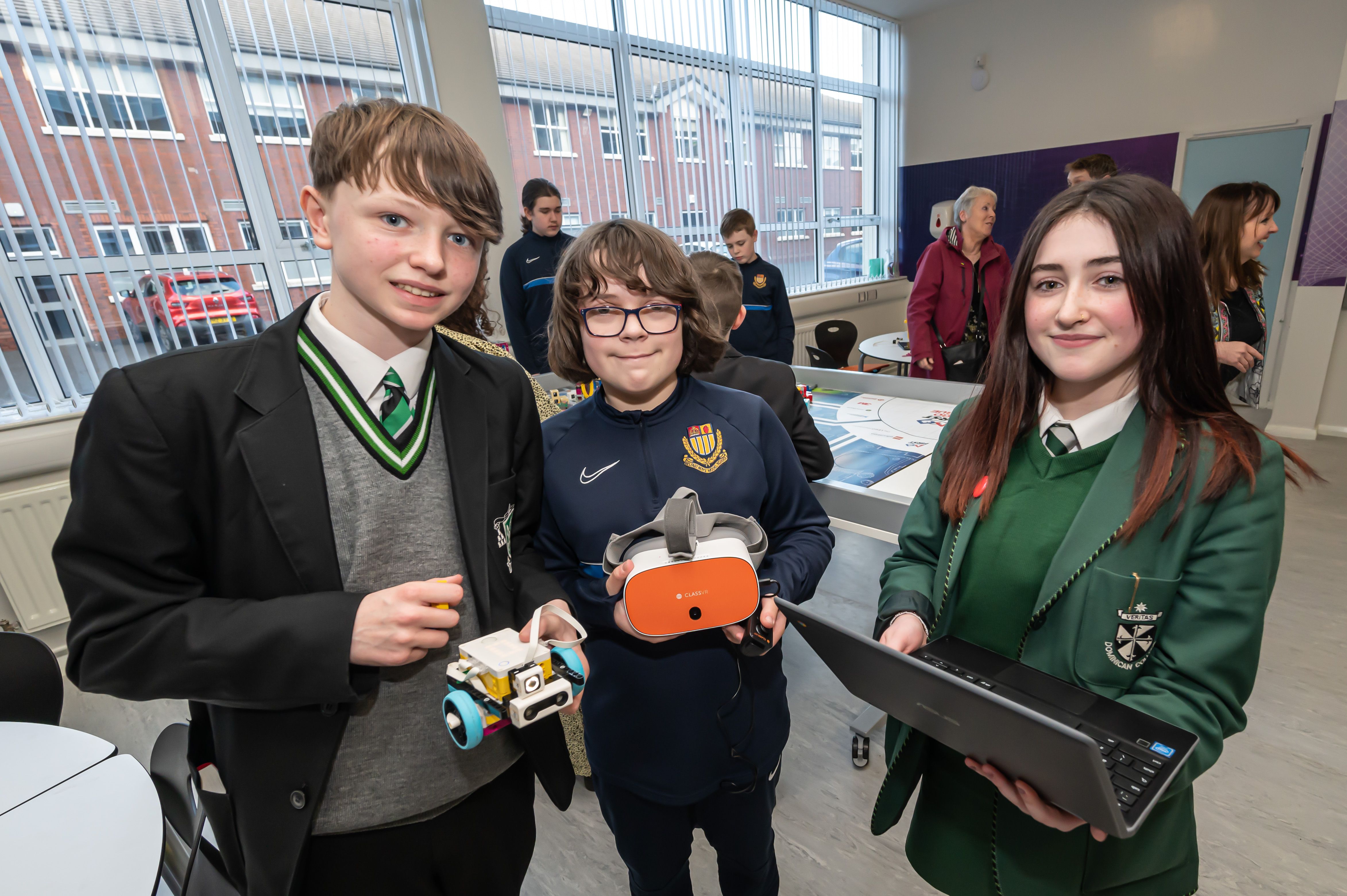 Students showcasing robotics projects and technology skills during a classroom event.