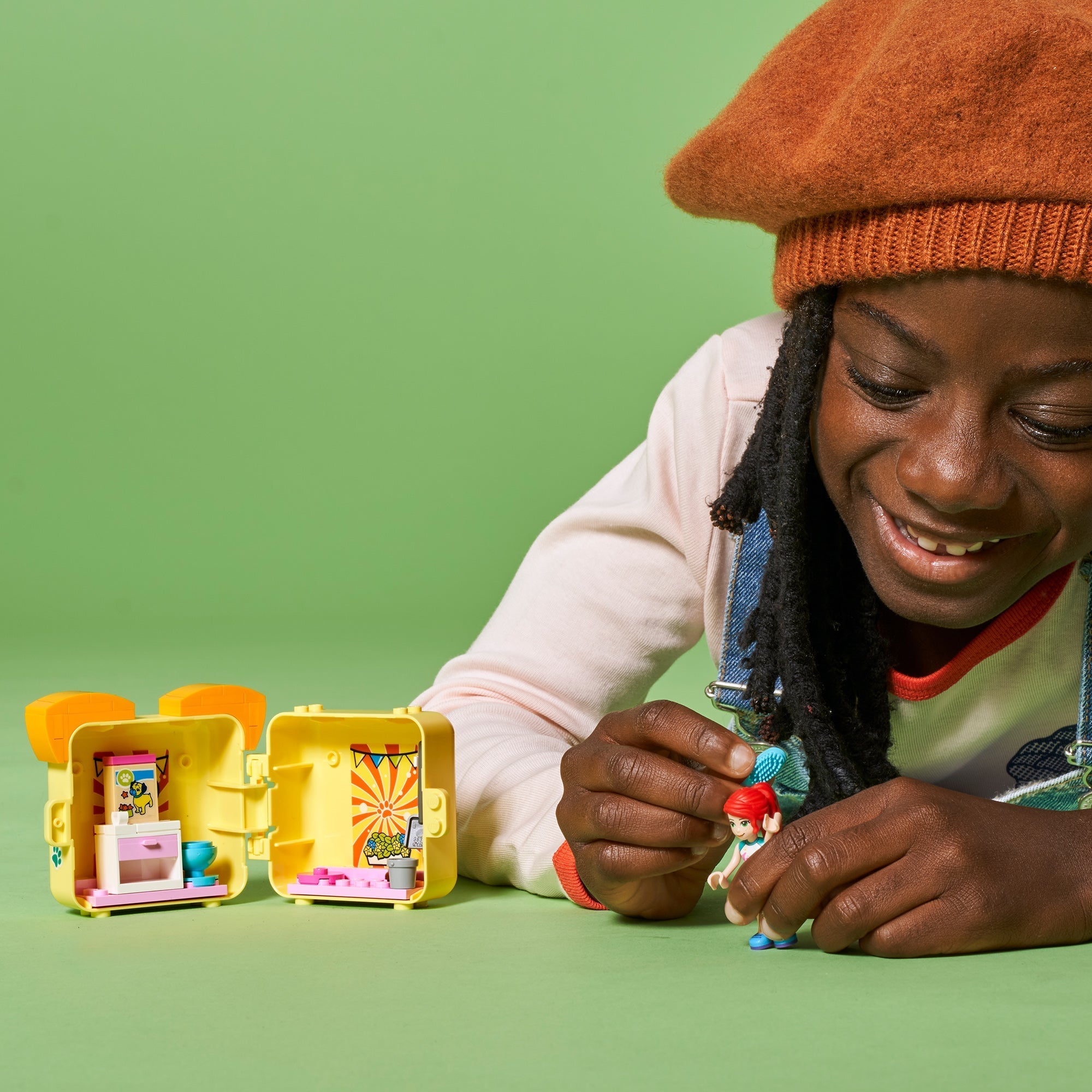 Child playing with LEGO Friends Mia's Pug Cube Playset 41664, featuring colorful accessories and characters.