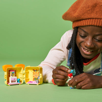 Child playing with LEGO Friends Mia's Pug Cube Playset 41664, featuring colorful accessories and characters.