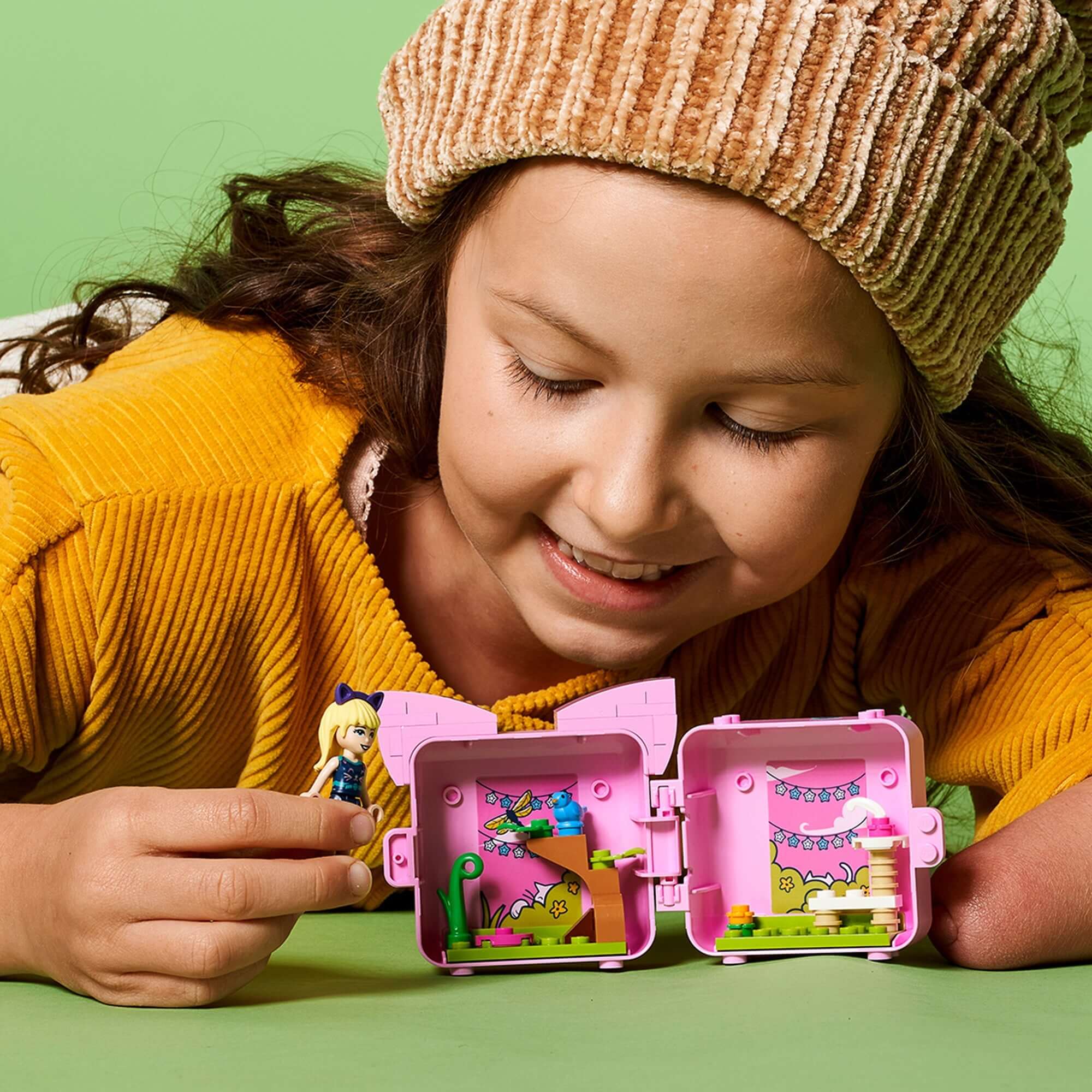 Girl exploring LEGO Friends Stephanie’s Cat Cube Playset, featuring a mini doll and colorful cat-themed accessories.