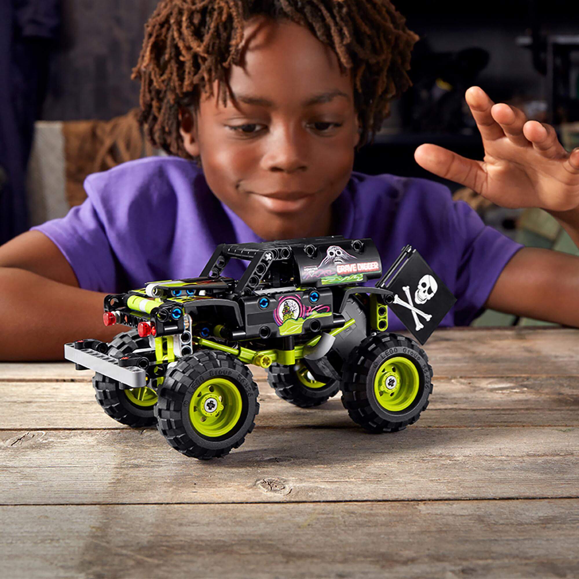 Child playing with LEGO® Technic Monster Jam Grave Digger toy 42118, showcasing creativity and fun in building.