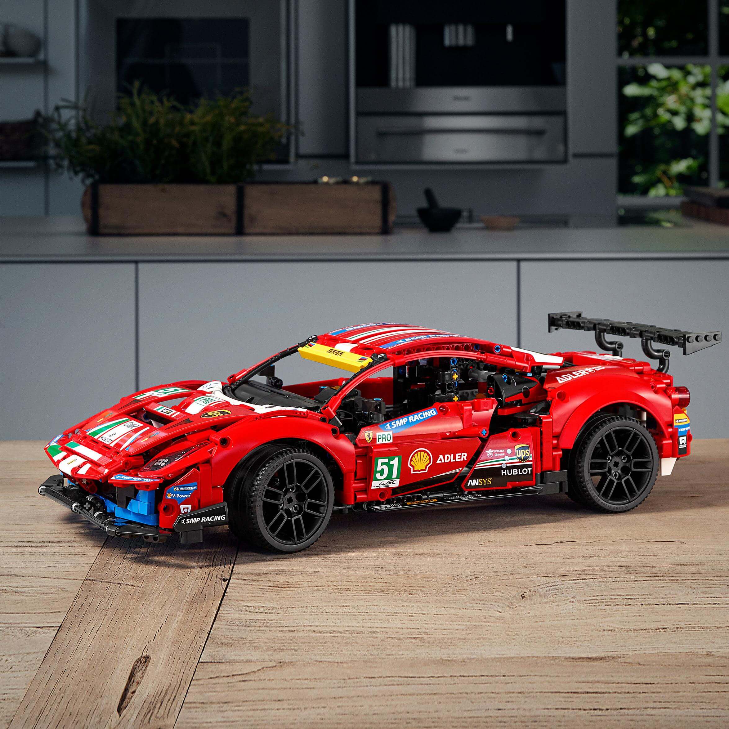 LEGO Technic Ferrari 488 GTE AF Corse #51 set 42125 displayed in a modern kitchen on a wooden surface.