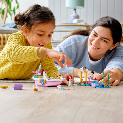 Child and adult enjoying LEGO Disney Ariel’s Celebration Boat set on the floor, highlighting fun building and play.