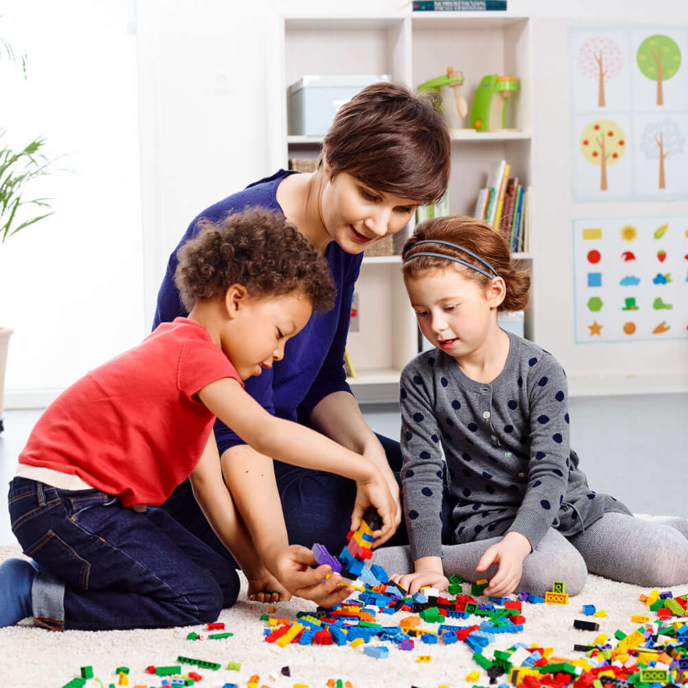 Children and a teacher collaborating with LEGO® bricks, inspiring creativity and imagination with the Creative Brick Set.
