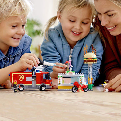 Kids playing with LEGO City Burger Bar Fire Rescue Engine Toy 60214 featuring fire truck and burger stand.