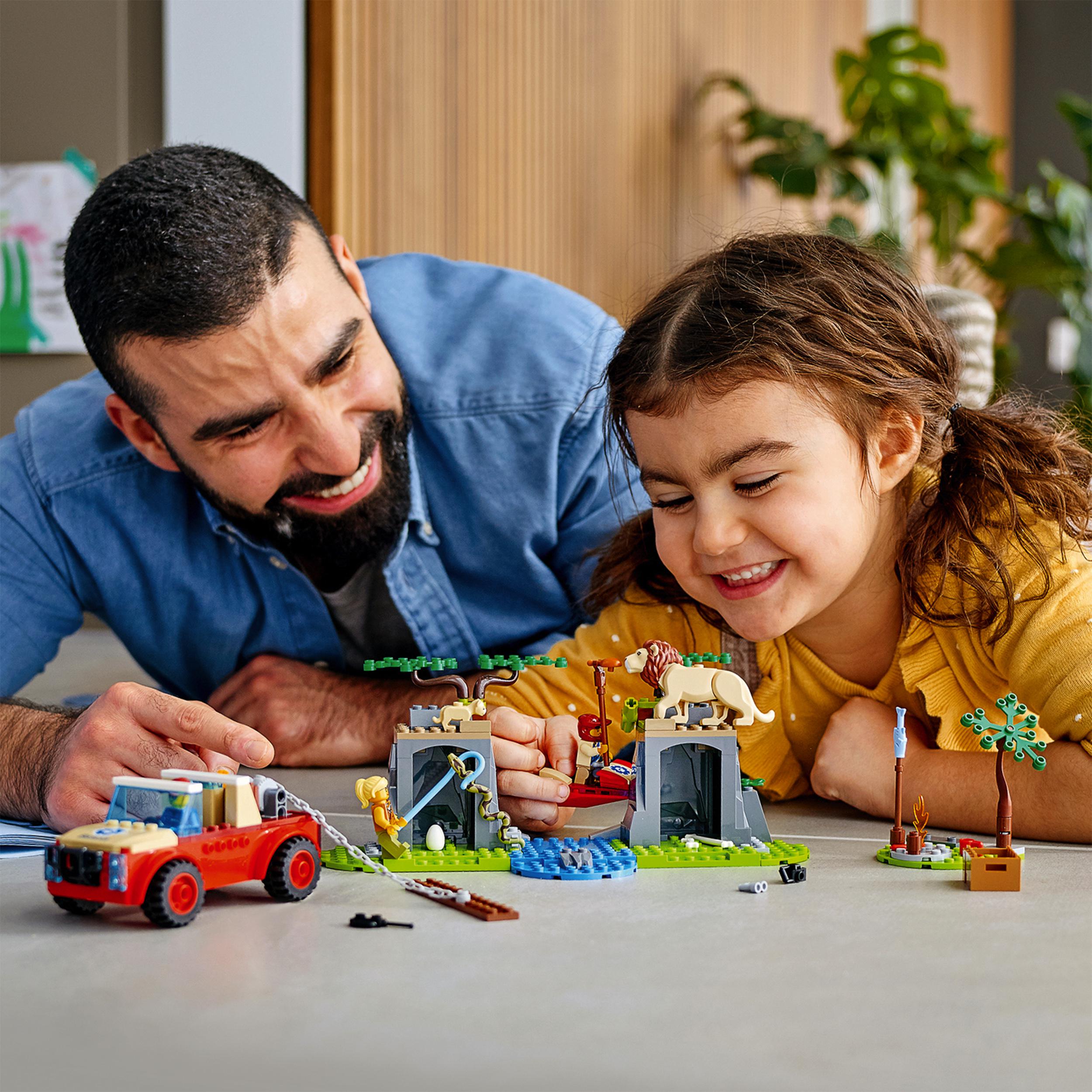 Family playing with LEGO® City Wildlife Rescue Off Roader Car Toy 60301, featuring animals and a rescue scene.
