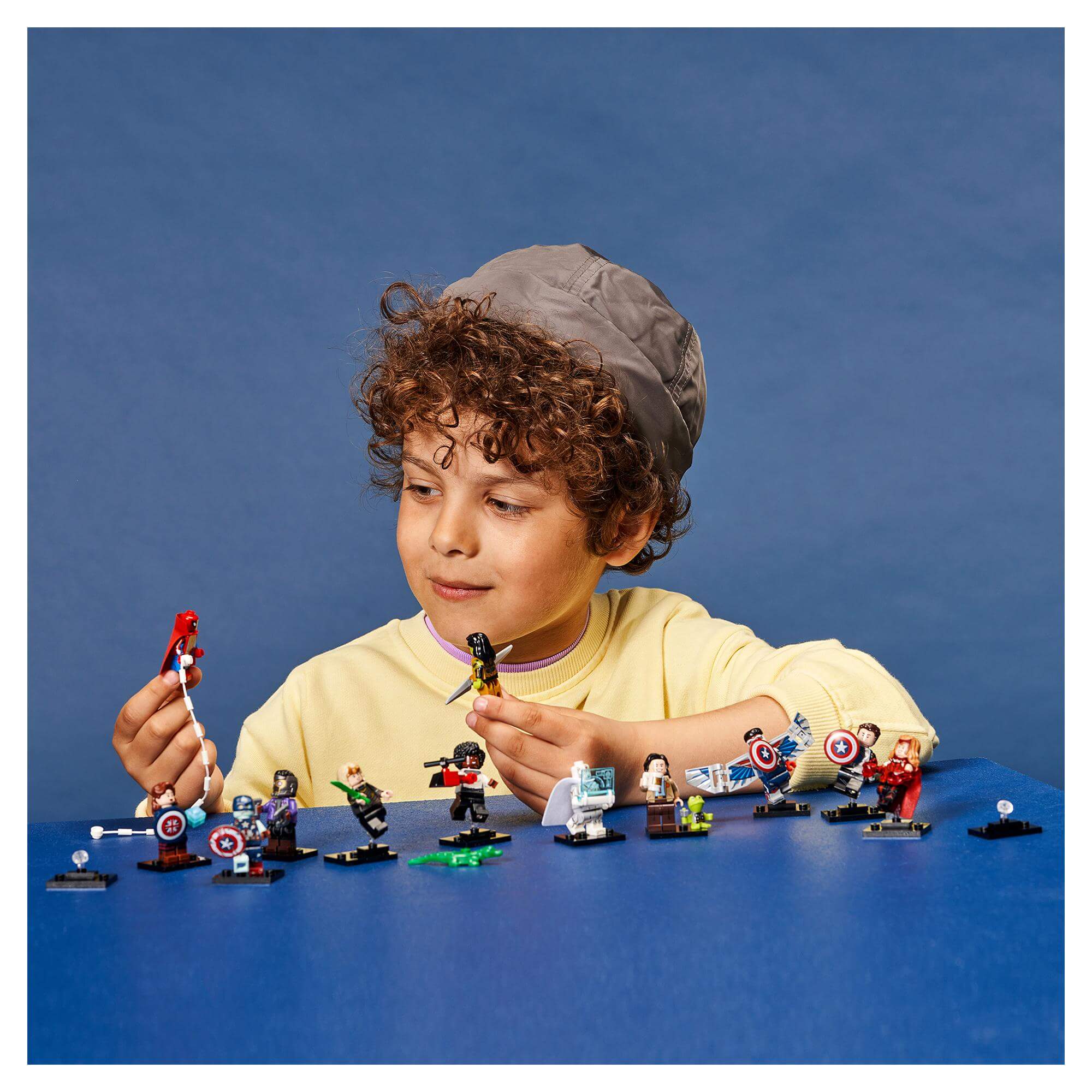 Child exploring LEGO® Minifigures Marvel Studios set 71031, showcasing mini superheroes and accessories.