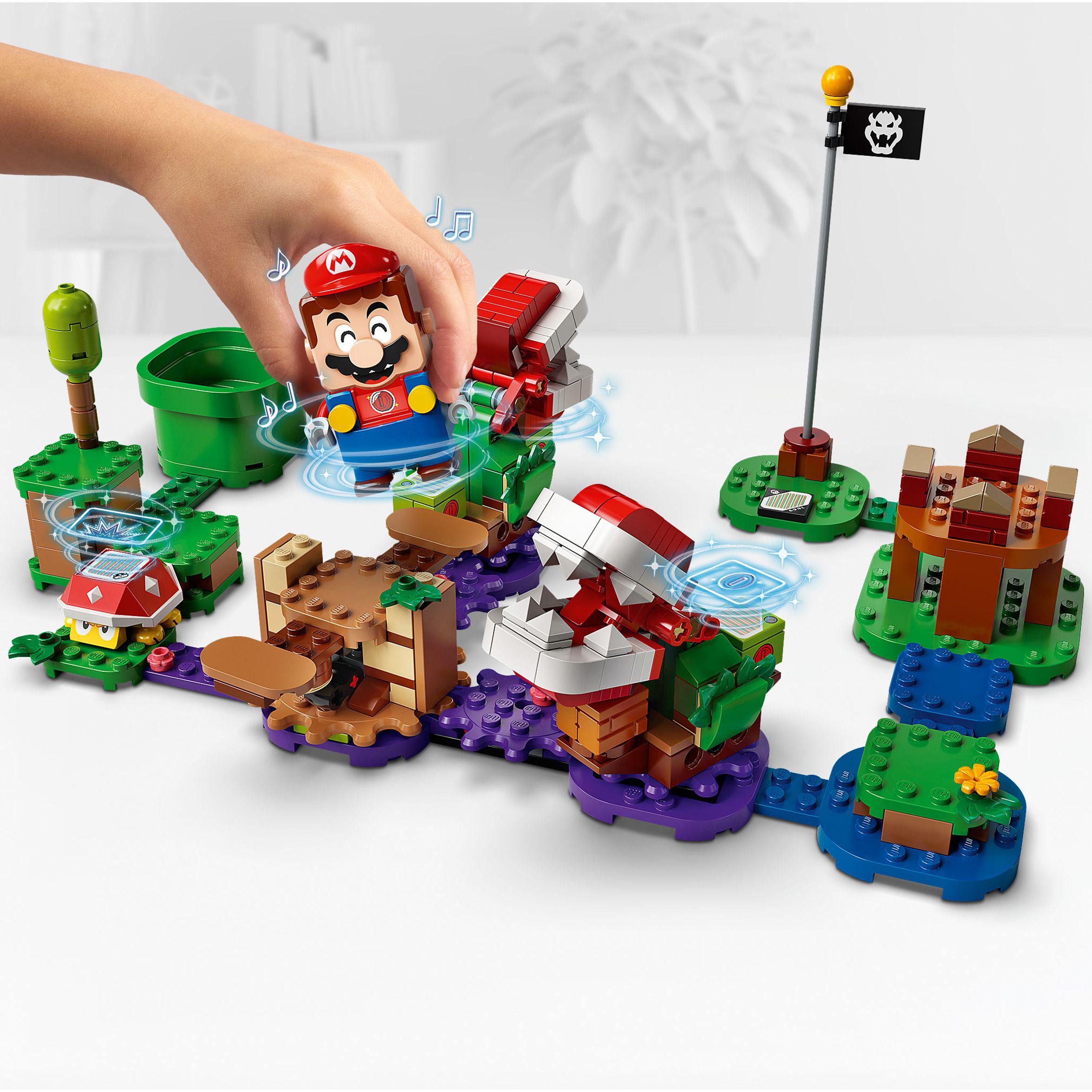 Child playing with LEGO® Super Mario Piranha Plant Expansion Set 71382 in vibrant Soda Jungle landscape.