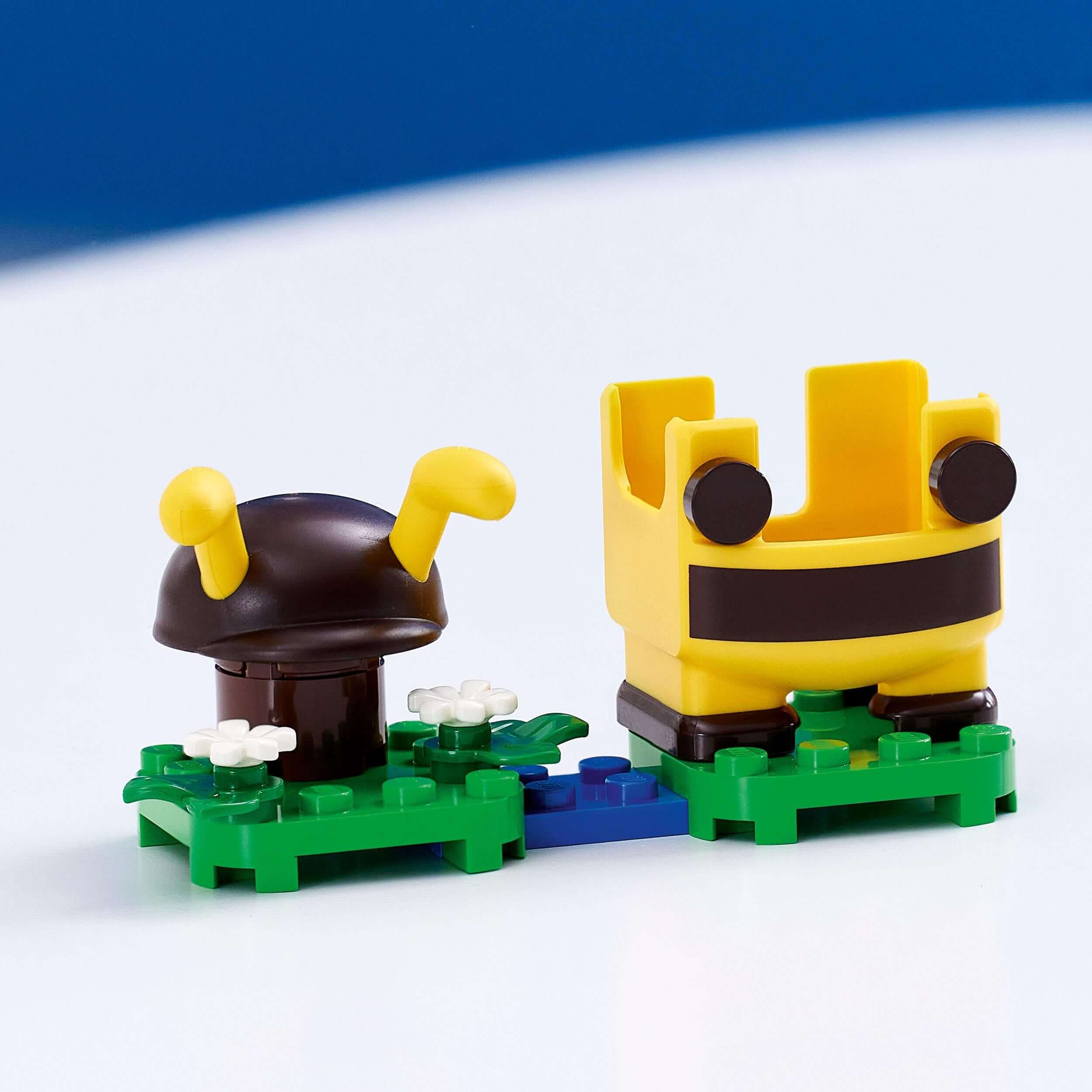 LEGO® Super Mario Bee Mario Power-Up Pack components, including a bee suit and flower elements on green base.