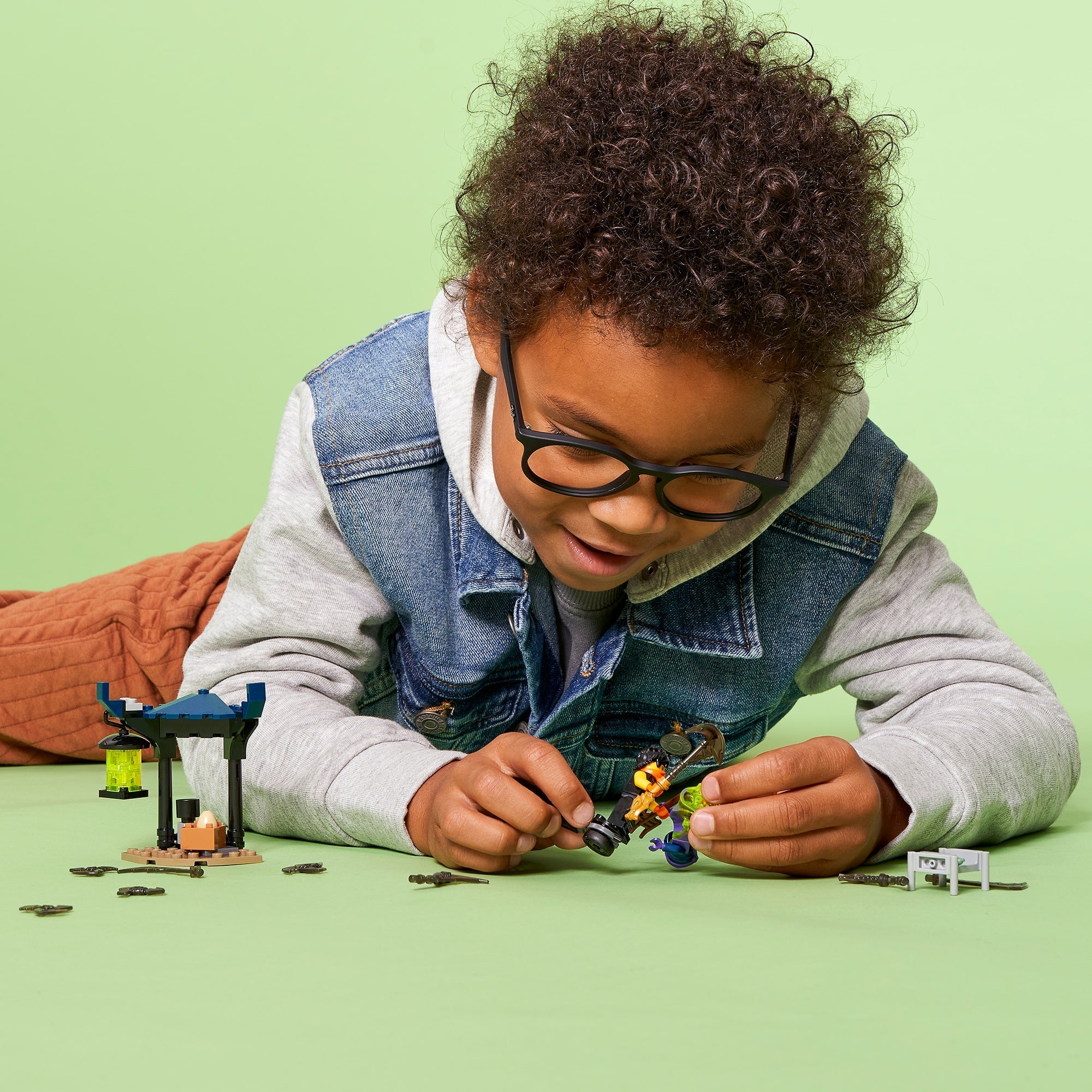 Child playing with LEGO® NINJAGO Epic Battle Set Cole vs. Ghost 71733, enjoying imaginative battle scenes.