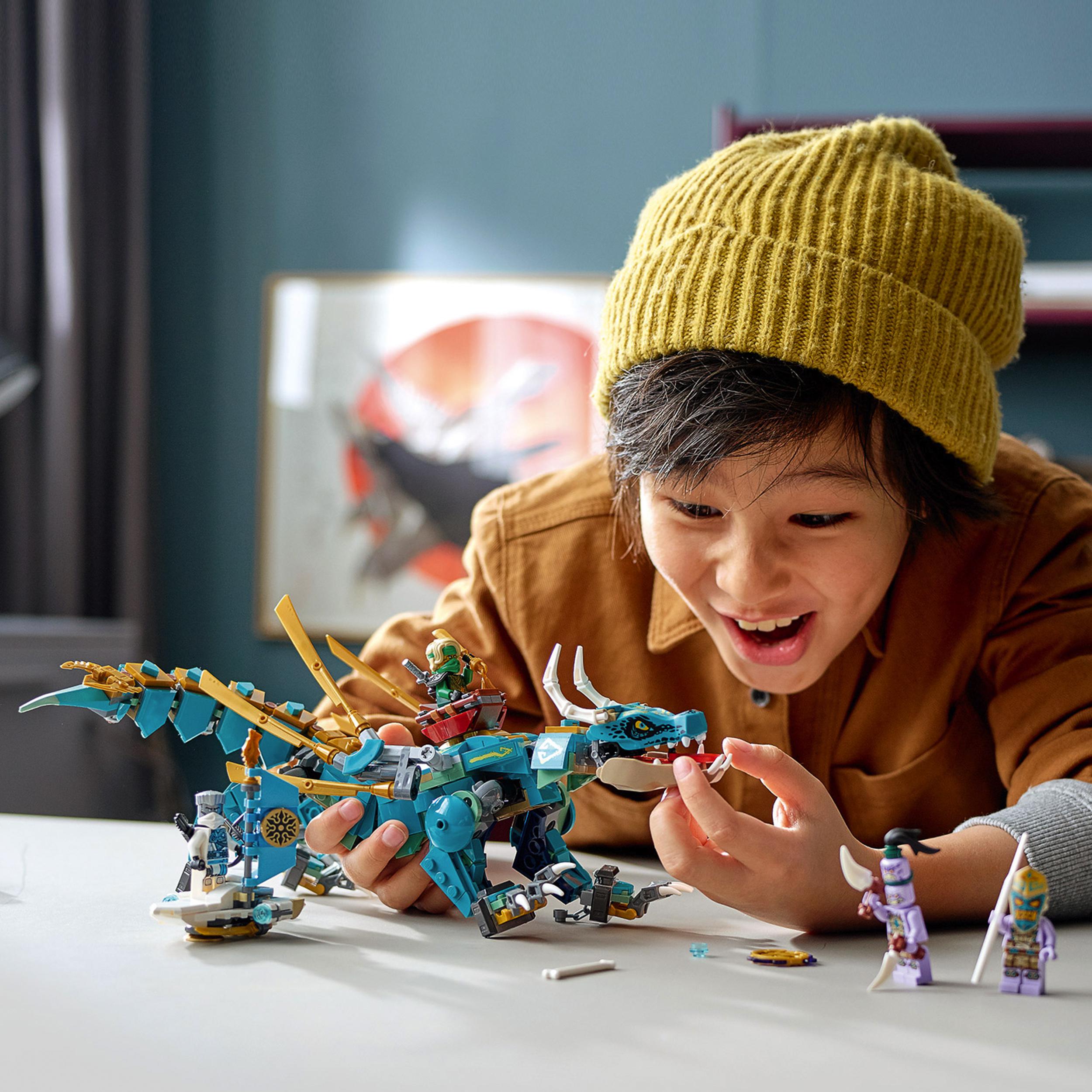 Child playing with LEGO® NINJAGO Jungle Dragon set 71746, enjoying island adventures with colorful toy figures.