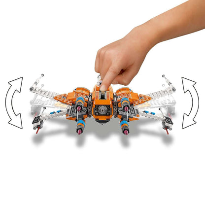 Child's hand manipulating LEGO® Star Wars Poe Dameron X-wing Fighter model for interactive play.
