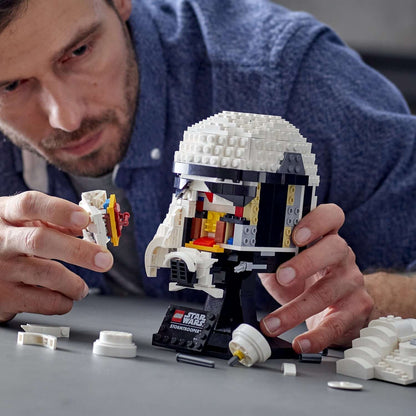 Adult building the LEGO® Star Wars Stormtrooper Helmet Model Set 75276, showcasing intricate details and creativity.