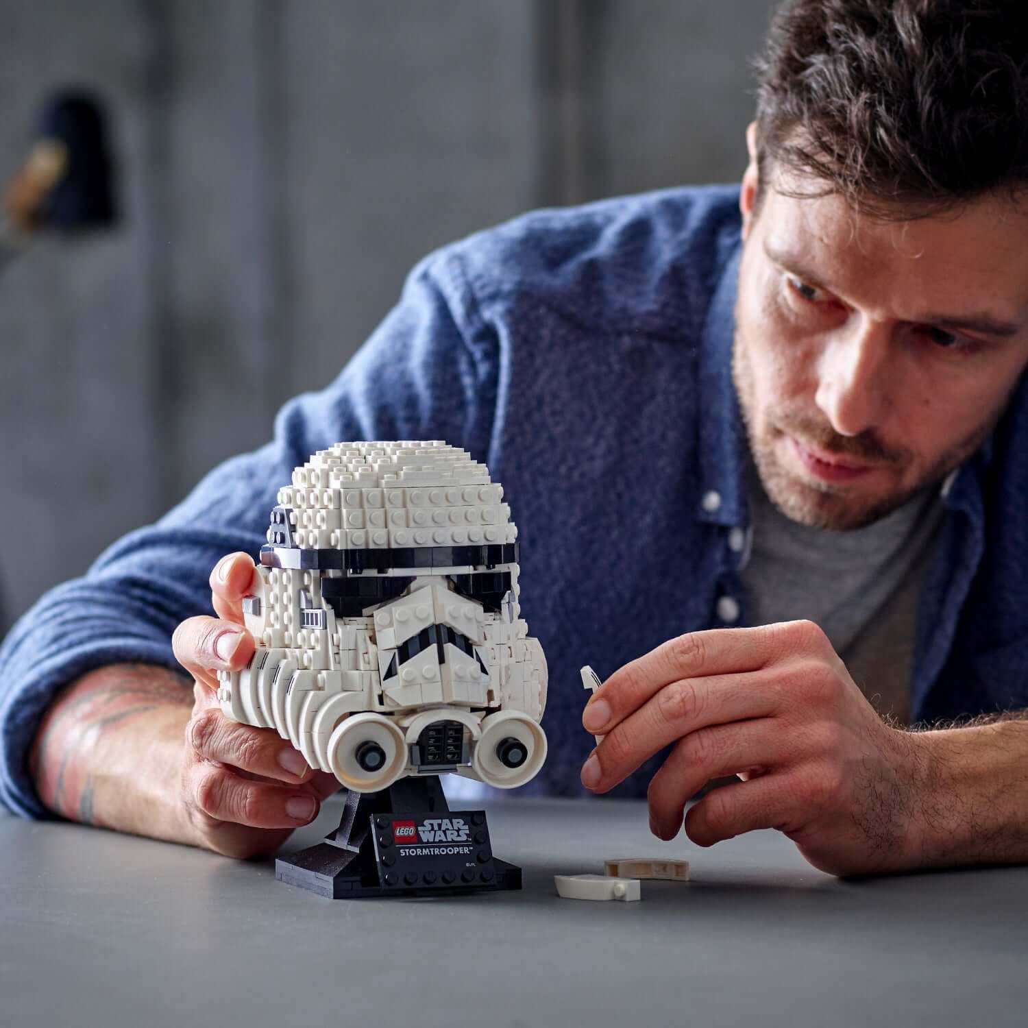 Person assembling LEGO® Star Wars Stormtrooper Helmet Model 75276, a detailed collectible for adults.