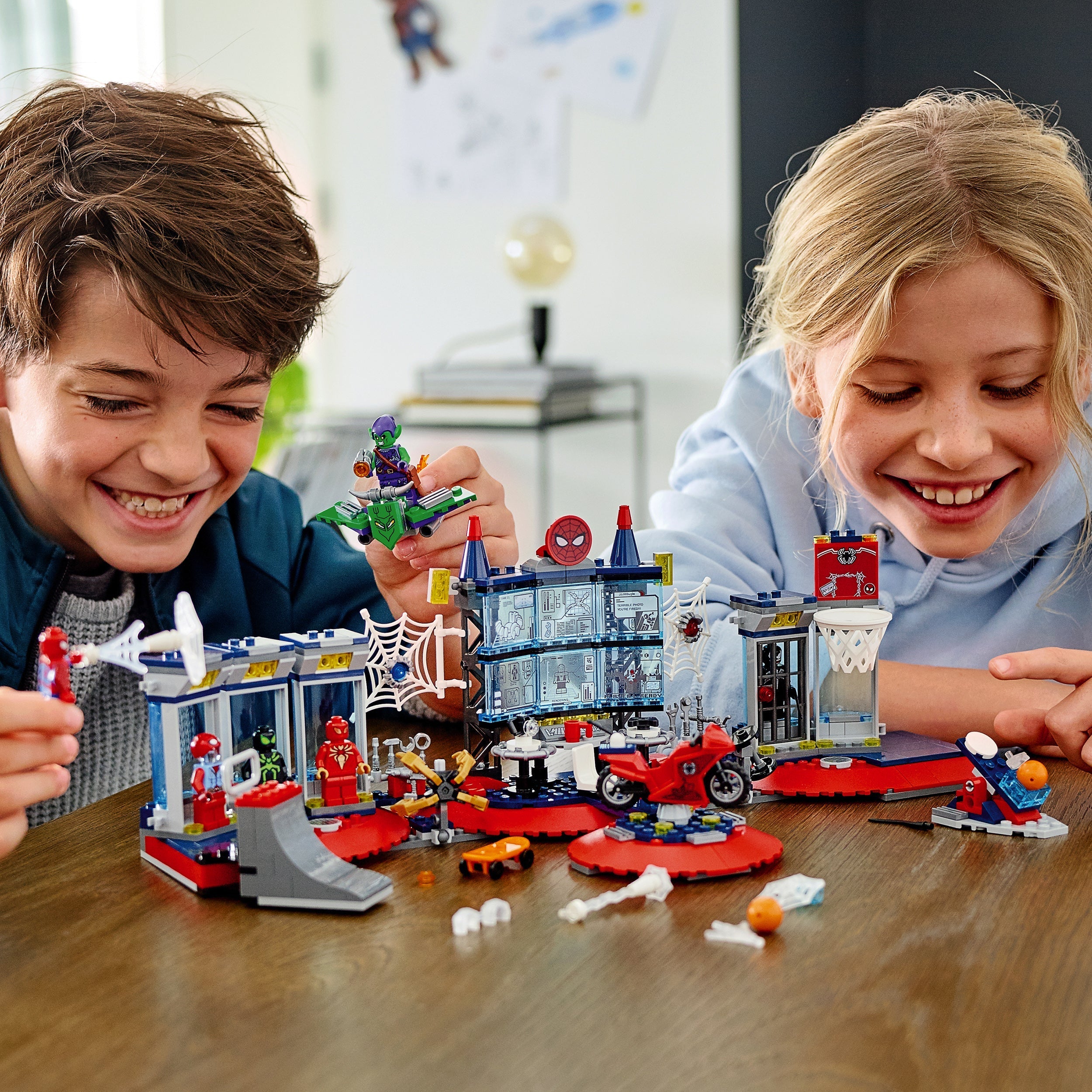 Kids enjoying LEGO® Marvel Spider-Man Attack on the Spider Lair set, playing in a vibrant superhero headquarters.