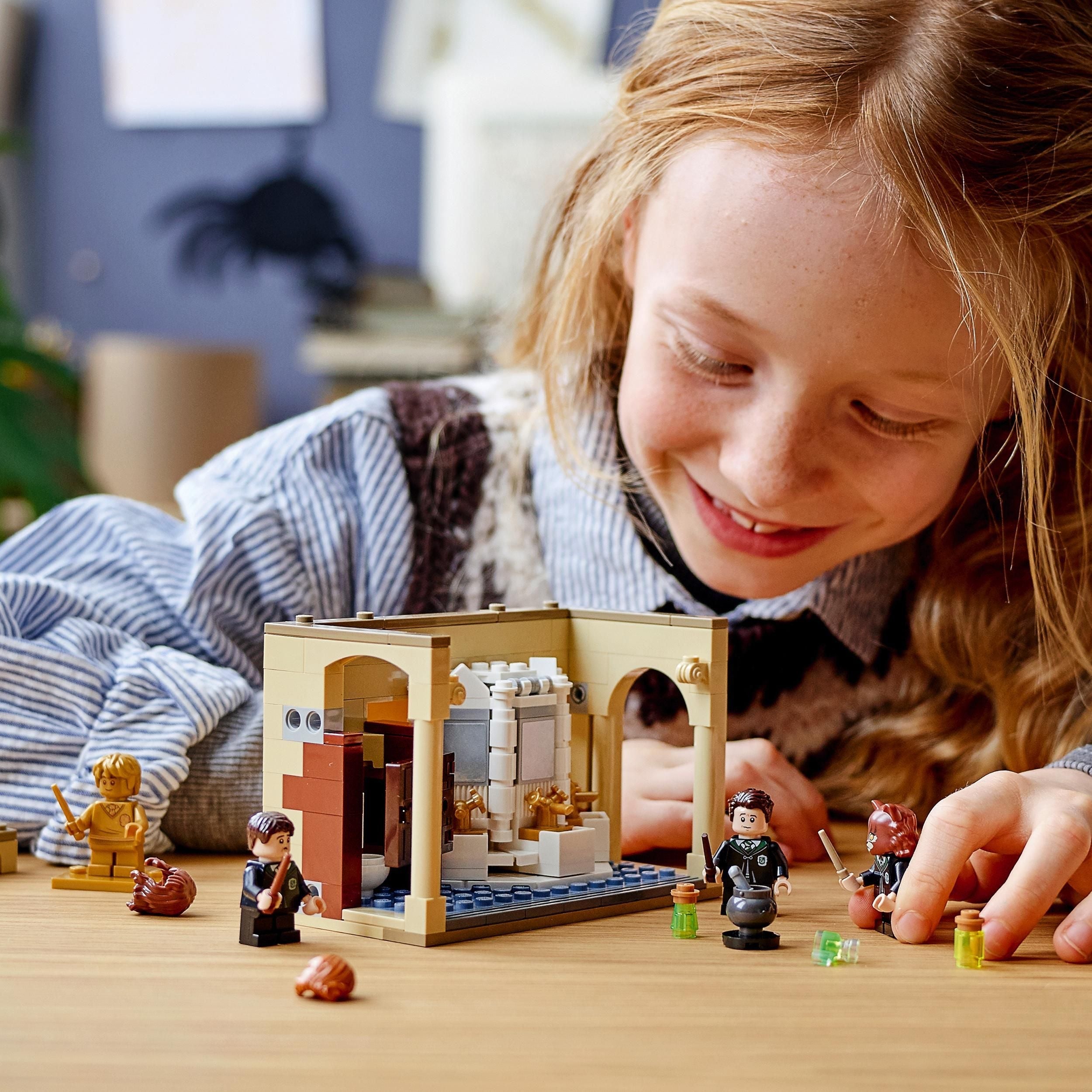 Child playing with LEGO® Harry Potter Hogwarts Potion Mistake Set 76386 in Hogwarts bathroom, crafting magical scenes.